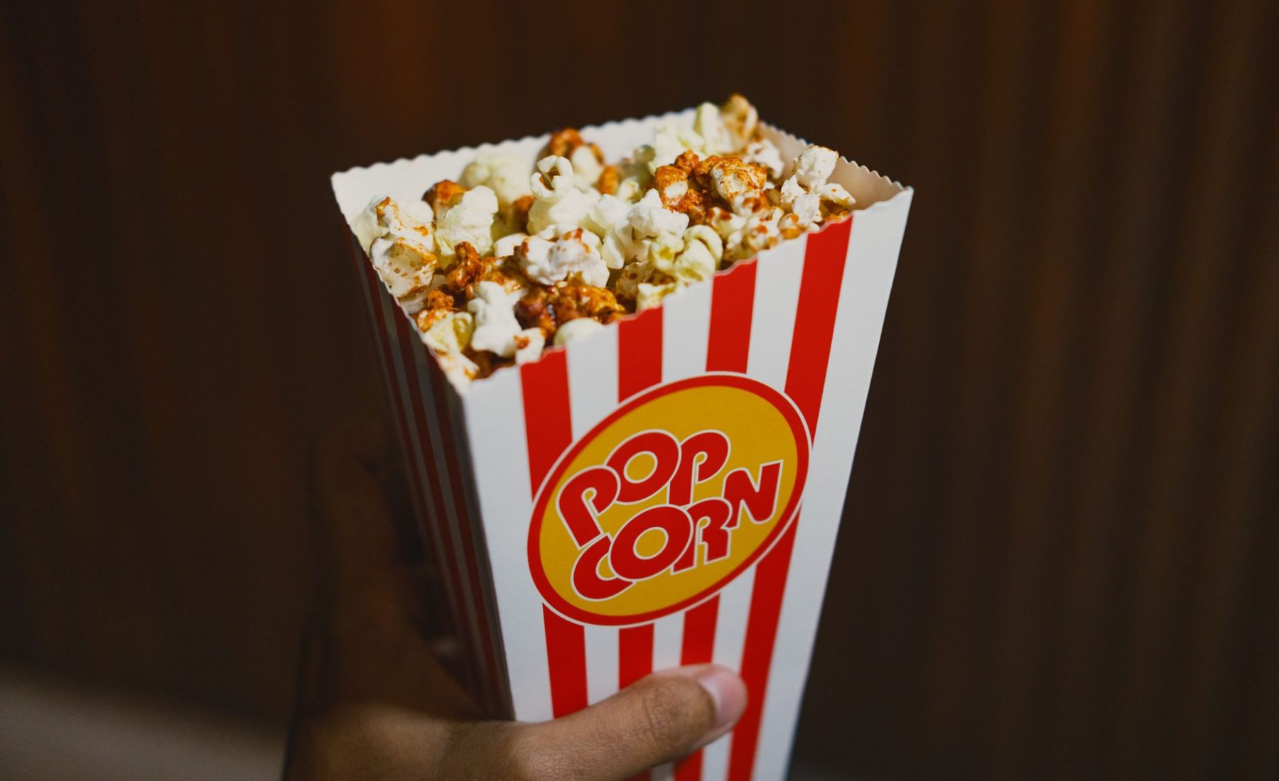 Frische Popcorn-Box vor dunklem Kinovorhang