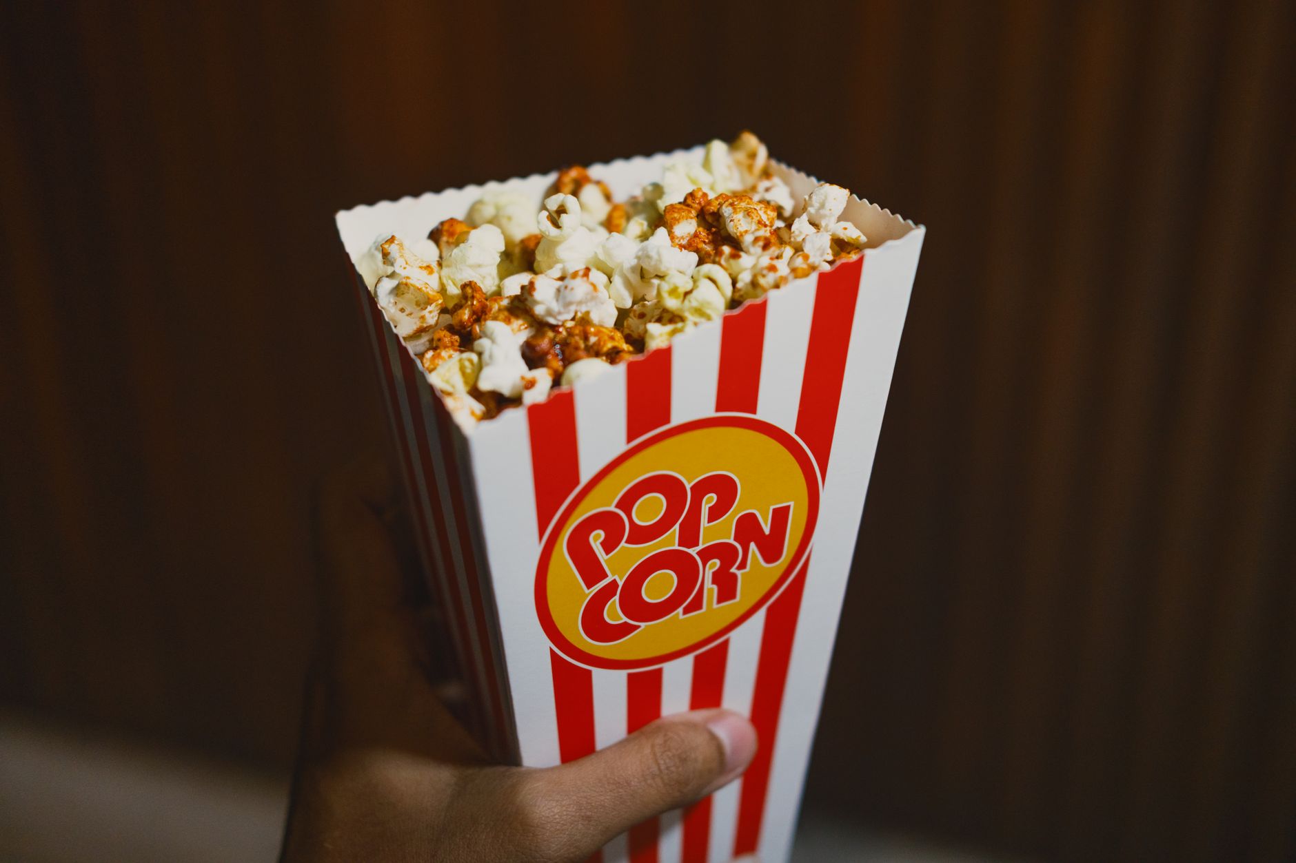 Frische Popcorn-Box vor dunklem Kinovorhang